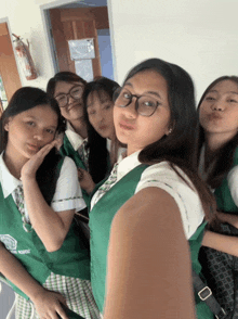 a group of girls are posing for a picture with one girl wearing a green vest that says ' north ' on the front