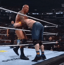 two men are wrestling in a ring with a gatorade bottle in the background