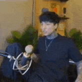 a man is sitting in front of a microphone .