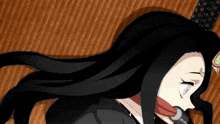a close up of a girl with long black hair laying on a blanket .