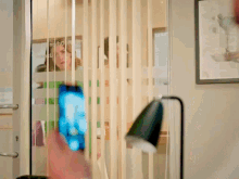 a person holding a cell phone in front of a sign that says ndh9 on it