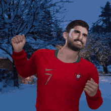 a man in a red shirt with the number 7 on it is standing in the snow