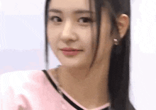 a close up of a woman 's face with a pink shirt on .