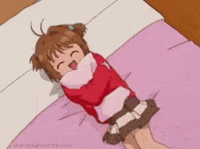 a little girl is laying on a bed holding a pillow .