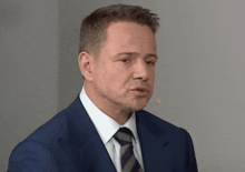 a man in a suit and tie with a microphone in his ear