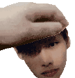 a close up of a person 's head with a hand holding it .