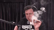 a man wearing headphones is smoking a cigarette and says " cioata " on the screen