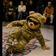 a teddy bear wearing sunglasses and a hoodie that says " gears "