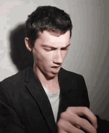 a man wearing a black jacket and a white t-shirt is making a funny face
