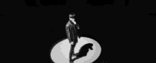 a black and white photo of a man standing in a dark room