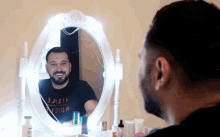 a man is looking at himself in a mirror wearing a shirt that says 1121