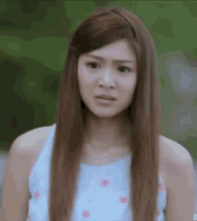 a young woman with long hair is making a funny face .