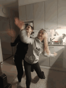 a woman wearing a puma sweatshirt is standing next to another woman