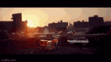 a drum set sits on a rooftop at sunset with a city in the background