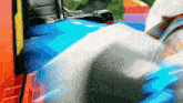 a blurred image of a blue car with a red brick wall in the background
