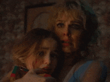 a woman and a little girl are looking at the camera with their faces covered .