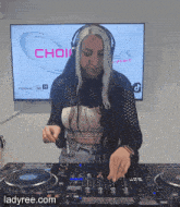 a woman wearing headphones is playing music in front of a screen that says choir