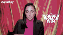 a woman wearing a pink turtleneck and a black jacket is standing in front of a pink background with the words wonder woman 1984 on it