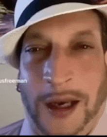 a close up of a man wearing a hat and beard .