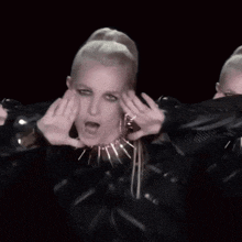 a woman wearing a necklace with spikes is making a face