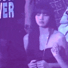 a woman in a strapless top is sitting in a dark room .