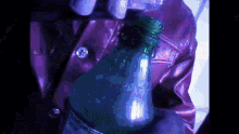 a person is opening a green bottle of soda with a lighter in their hand .
