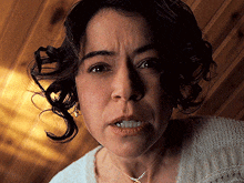 a close up of a woman 's face with a wooden background