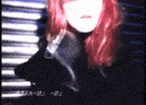 a woman with red hair is standing in front of a wall