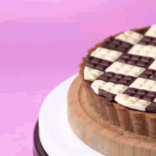 a cake with a checkered pattern on it is on a wooden plate