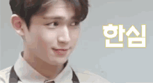 a close up of a young man wearing an apron and a white shirt making a funny face .