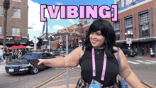 a woman stands in front of a sign that says ' vibing '