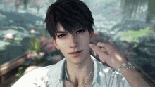 a man wearing a white shirt and a necklace is standing in front of a pond .