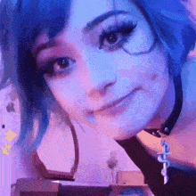a woman with blue hair is wearing a choker and smiling at the camera .