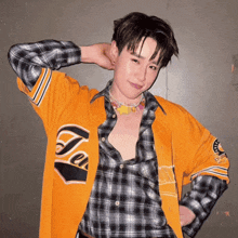 a man wearing a plaid shirt and a yellow jacket with the word ten on it