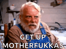 a man with a beard is sitting in a chair with the words get up motherfukkas below him