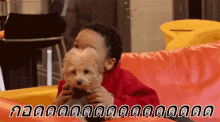 a young boy is sitting on a couch holding a small brown dog .