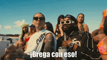 a group of people are sitting on a boat and one of them is wearing sunglasses and says brega con eso
