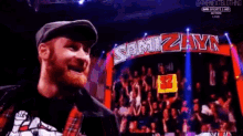 a man is holding a sign that says nyz in front of a crowd .