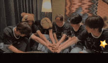 a group of young people sitting in a circle with their hands together