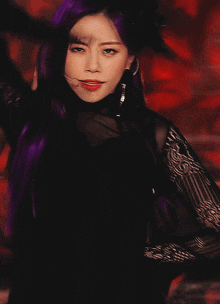a woman with purple hair is wearing a black lace top
