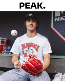 a man wearing a minnesota shirt is holding a baseball and a glove
