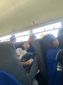 a group of people sleeping on a school bus with one wearing a jersey that says ' washington nationals ' on it