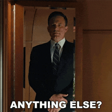 a man in a suit and tie is standing in a doorway with the words anything else below him