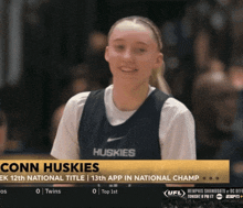 a female basketball player named conn huskies is on a television screen