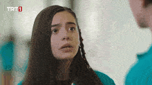 a girl in a blue shirt with trt1 written on the bottom right