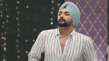 a man wearing a turban and striped shirt is dancing