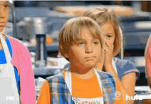 a young boy wearing an orange shirt that says nathan on it