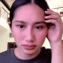 a woman is touching her forehead with her hand .