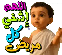 a baby is standing in front of a colorful arabic text