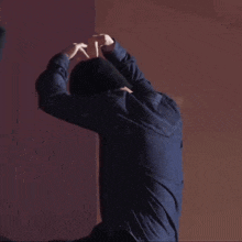 a man in a blue shirt is dancing with his arms up in the air